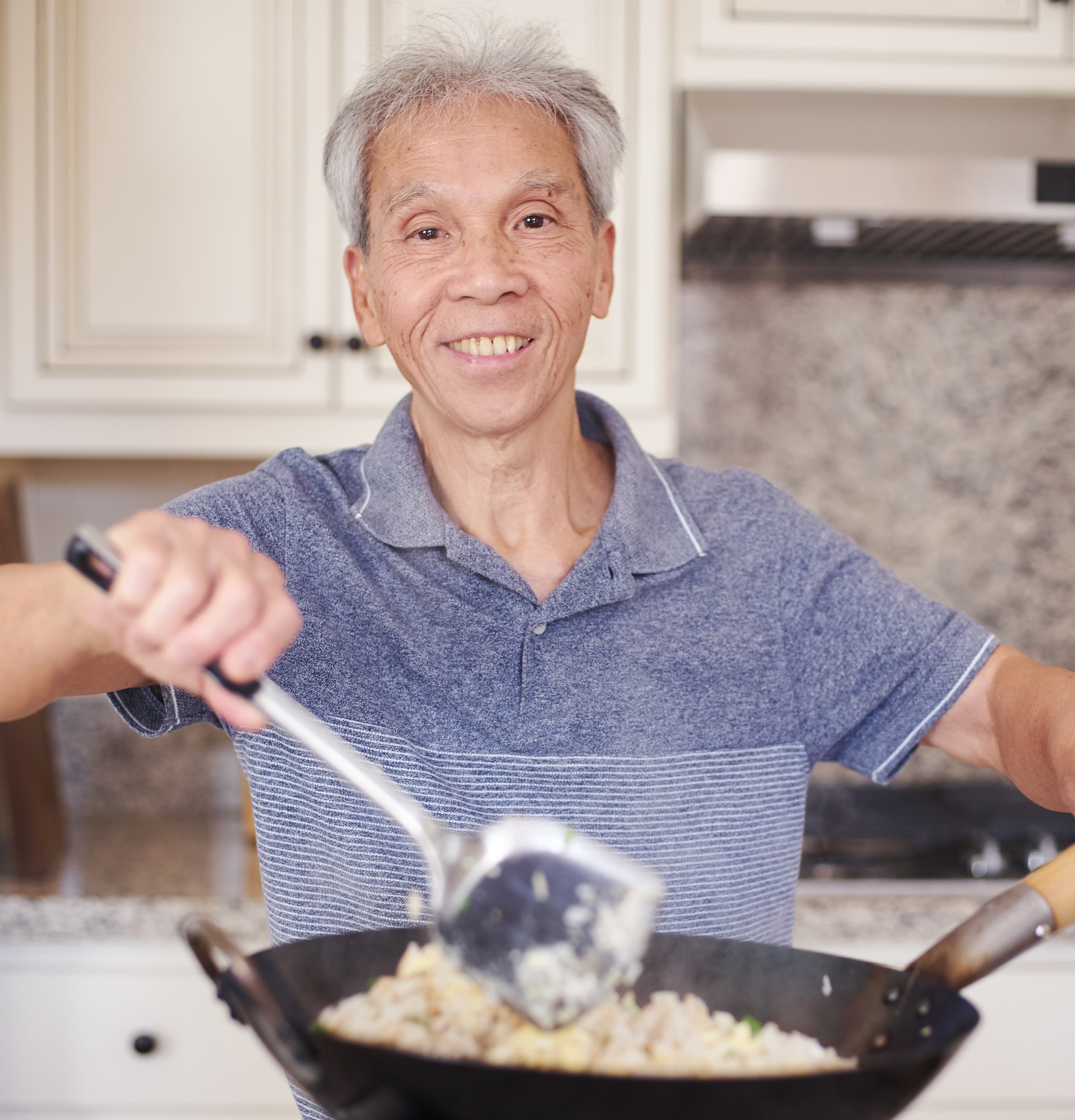 Daddy Lau cooking fried rice in a wok